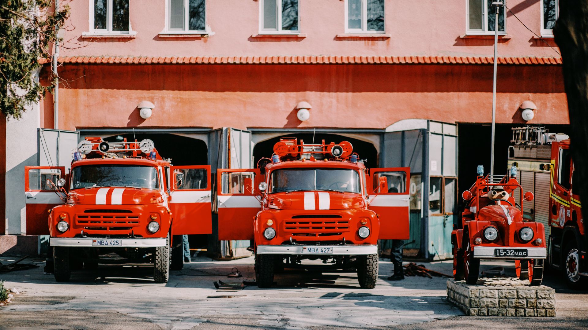 Three fire trucks parked in a fire department.