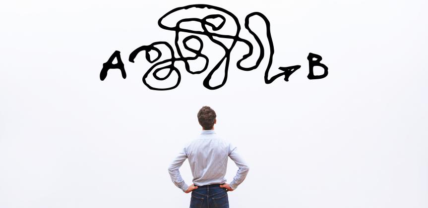The back of a man looking at a white board with a big scribble black line between points A and B