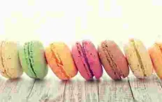 a horizontal row of colorful sandwich cookies shaped like hamburgers