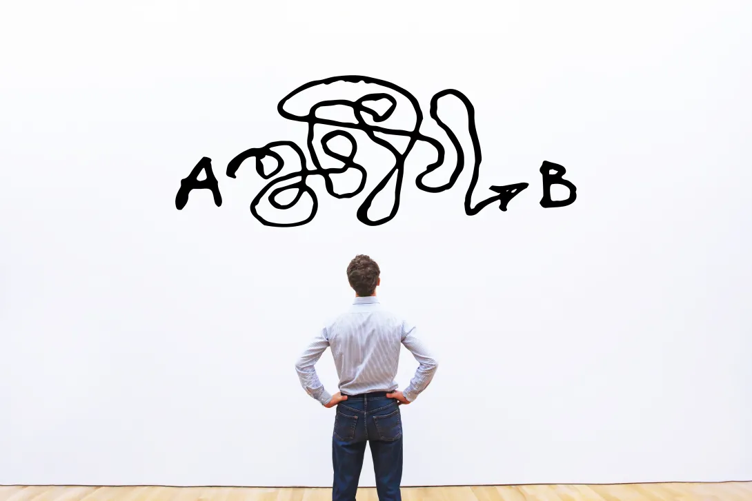 The back of a man looking at a white board with a big scribble black line between points A and B