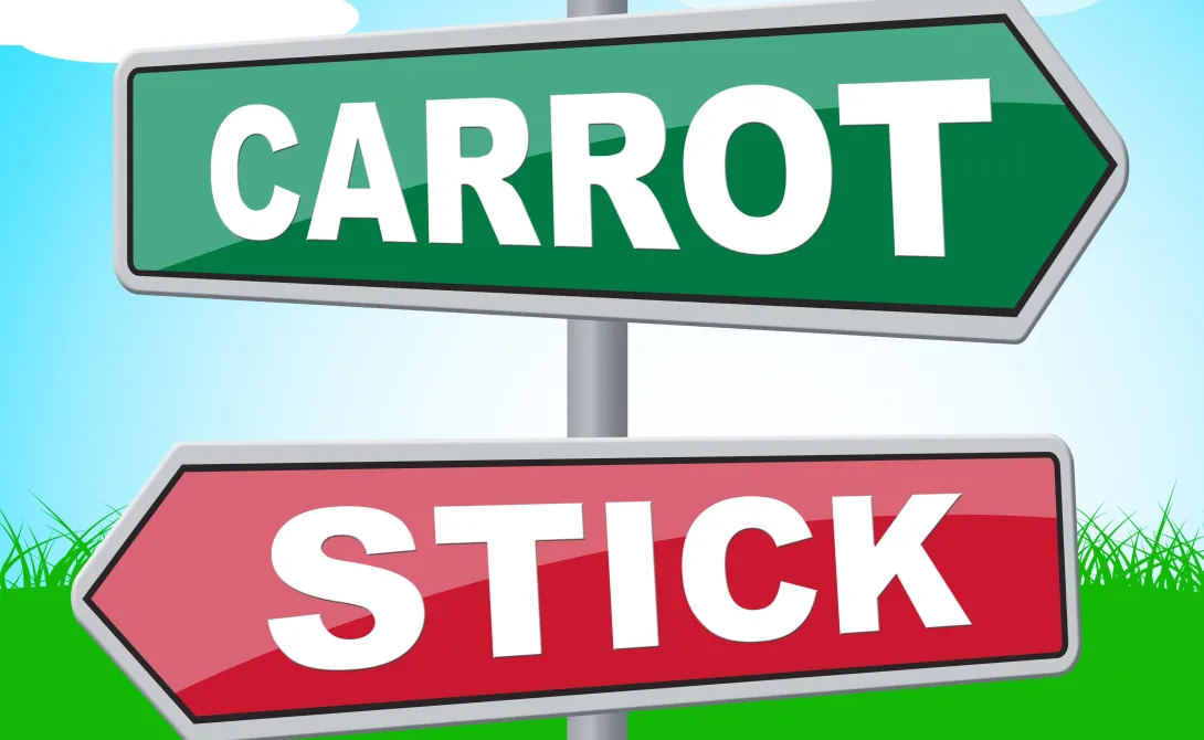 Two directional signs: one that reads "carrot" another that reads: "stick."